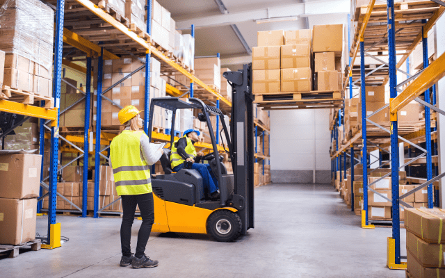 Mitarbeiter arbeiten mit Gabelstapler im Lagerhaus
