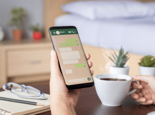 Person schreibt Nachricht auf Smartphone im Schlafzimmer
